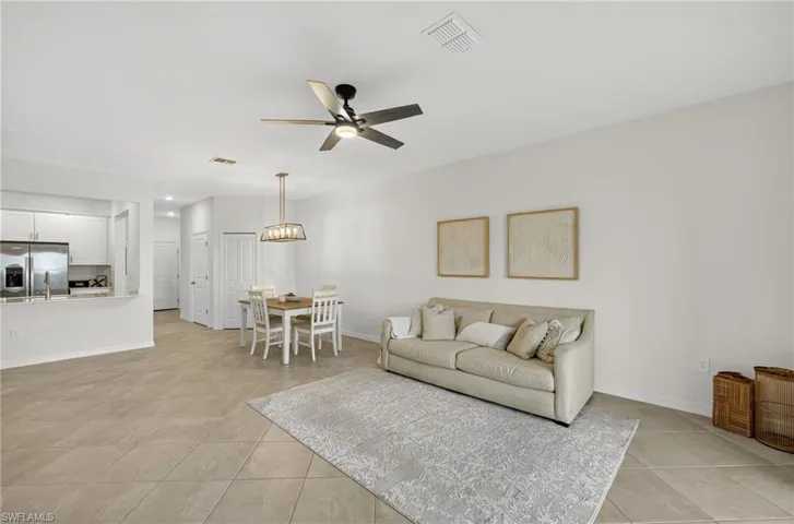 Living room featuring light tile patterned floors and a ceiling fan