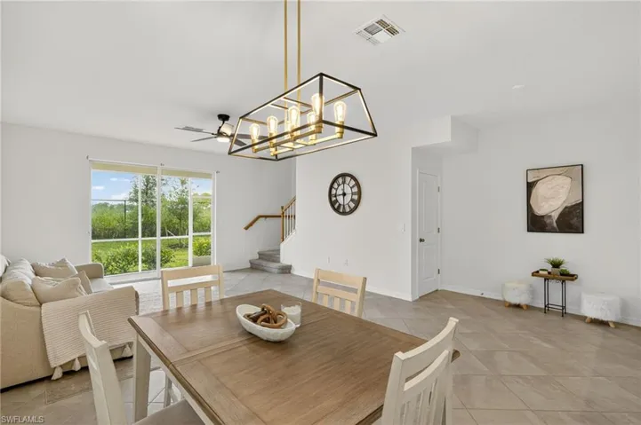 Dining room with stairs, light tile patterned floors, and a chandelier