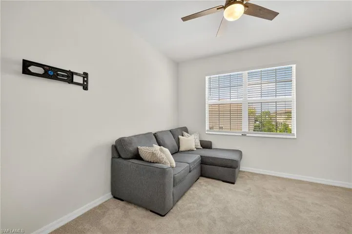 Sitting room with a ceiling fan and light carpet