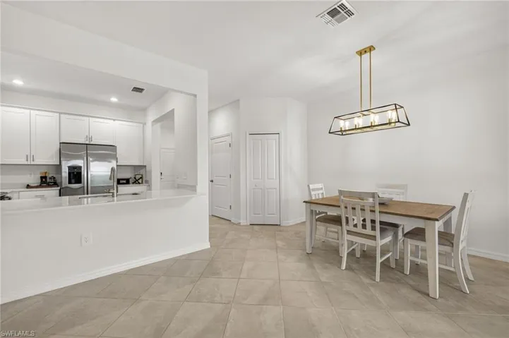Dining space featuring recessed lighting, light tile patterned floors, and a chandelier
