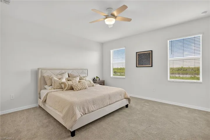 Bedroom featuring light carpet and a ceiling fan