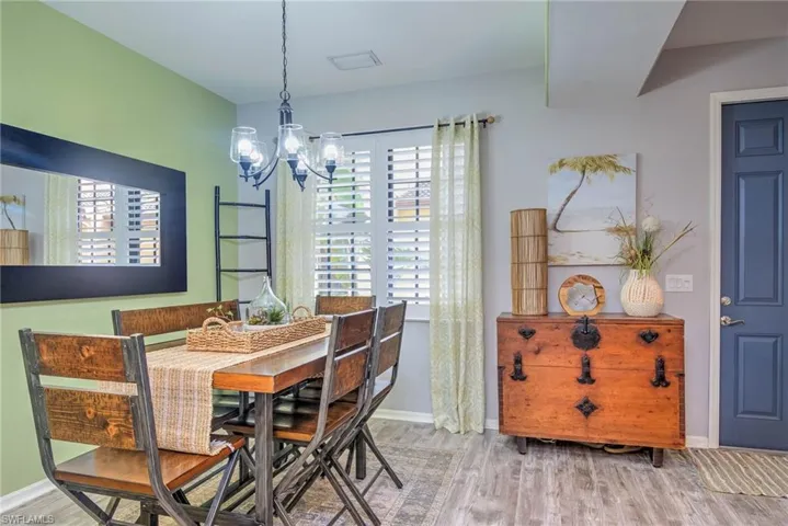 Dining space featuring an inviting chandelier, wood finished floors, and baseboards