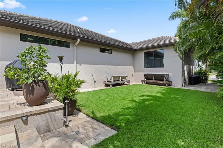 Back of house featuring a lawn and a patio