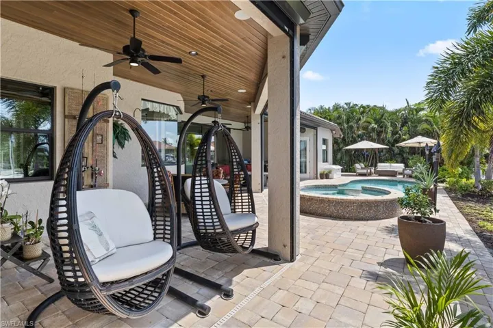 View of patio featuring ceiling fan and an in ground hot tub