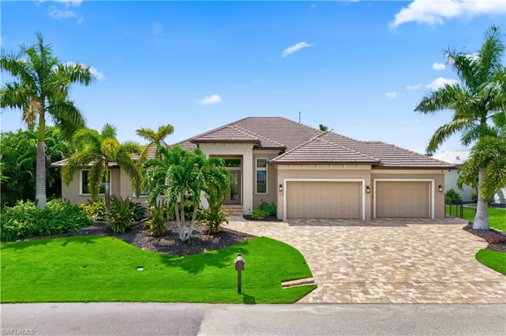 View of front of property with a garage and a front lawn
