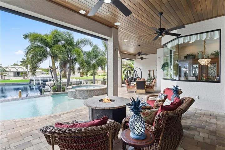 View of patio with a water view, ceiling fan, outdoor lounge area, and a pool with hot tub