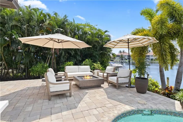 View of patio featuring a water view and an outdoor living space with a fire pit