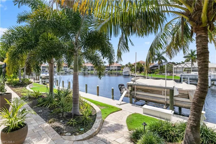 View of dock featuring a lawn and a water view