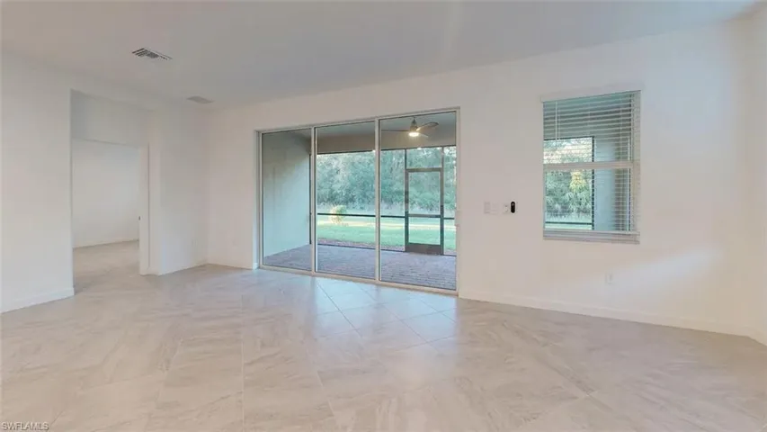 Spacious room featuring light-toned tile flooring and white walls