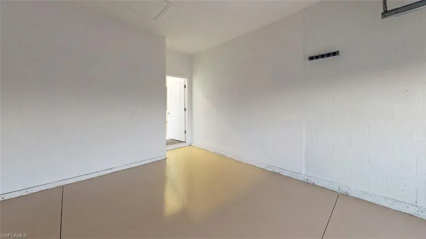 Concrete flooring with a protective coating, painted block wall, painted drywall, and a white door with a paneled design