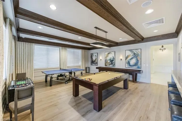 Game room with light wood-type flooring, beam ceiling, visible vents, a decorative wall, and billiards