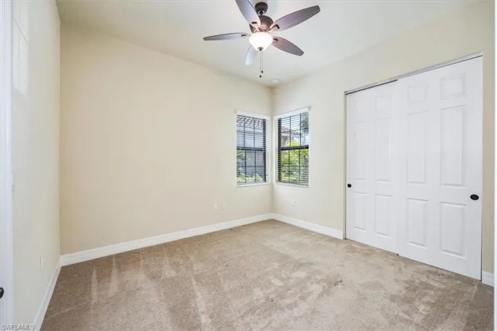 Unfurnished bedroom with baseboards, carpet flooring, ceiling fan, and a closet