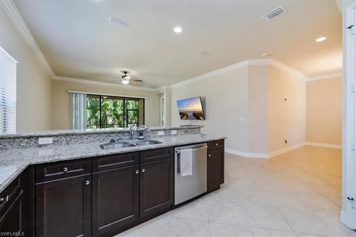 Kitchen with a sink, visible vents, ornamental molding, and dishwasher