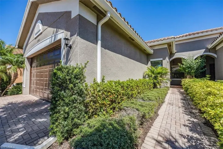 View of home's exterior featuring a tile roof, stucco siding, and a garage