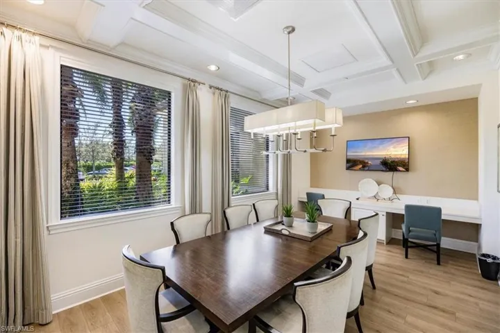Dining space with light wood-style floors, baseboards, coffered ceiling, and beamed ceiling