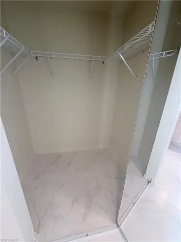 Walk in closet with light marble finish floors