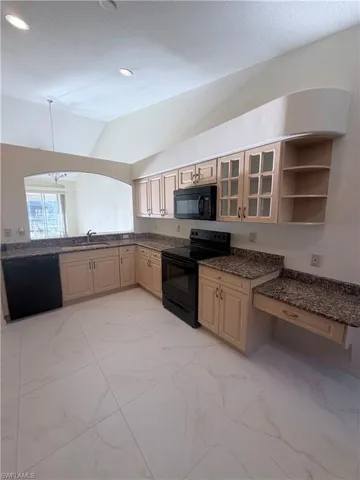 Kitchen featuring black appliances, glass fronted cabinets, light marble finish floors, open shelves, and vaulted ceiling