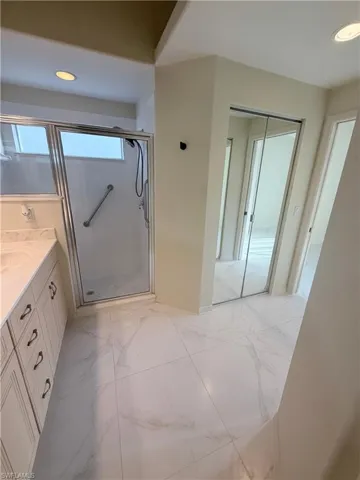 Full bathroom with vanity, recessed lighting, a stall shower, and light marble finish flooring