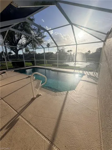 Swimming pool with a sunroom, glass enclosure, and a patio area