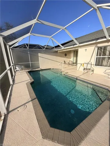 Swimming pool featuring a patio area, a sunroom, and a lanai