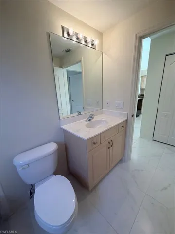 Bathroom featuring light marble finish flooring and vanity