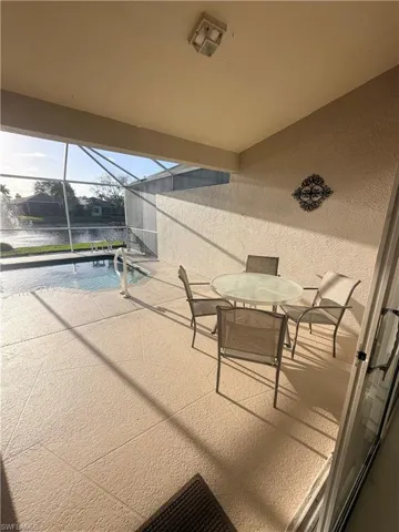 View of patio / terrace featuring a sunroom, an outdoor pool, outdoor dining area, and glass enclosure