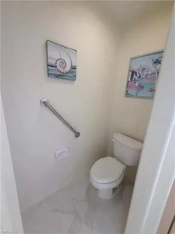 Bathroom featuring light marble finish floors and toilet