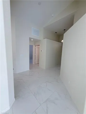 Spare room featuring baseboards and light marble finish flooring