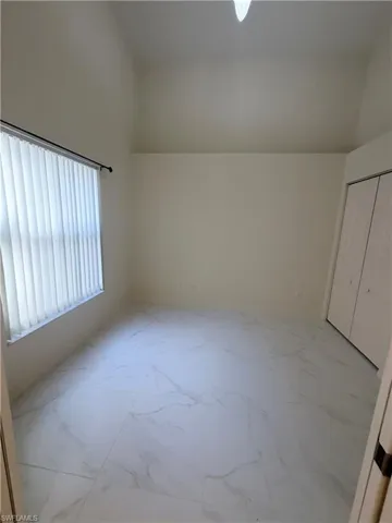 Bonus room with lofted ceiling and light marble finish flooring