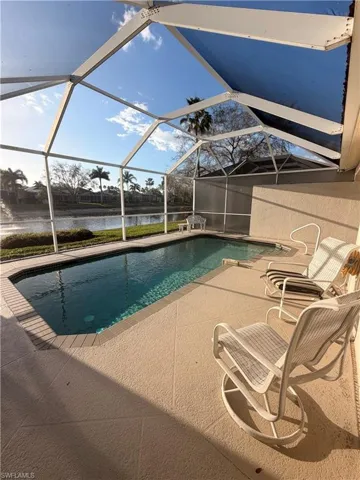 Outdoor pool featuring a sunroom, a water view, and a lanai