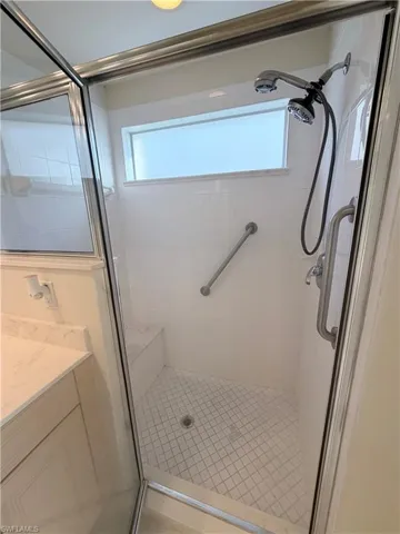 Full bathroom with a shower stall, vanity, and plenty of natural light