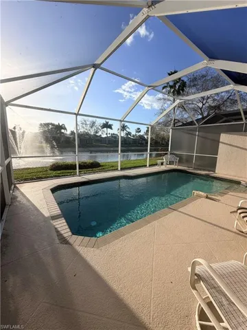 Swimming pool with a sunroom, a patio area, and a lanai