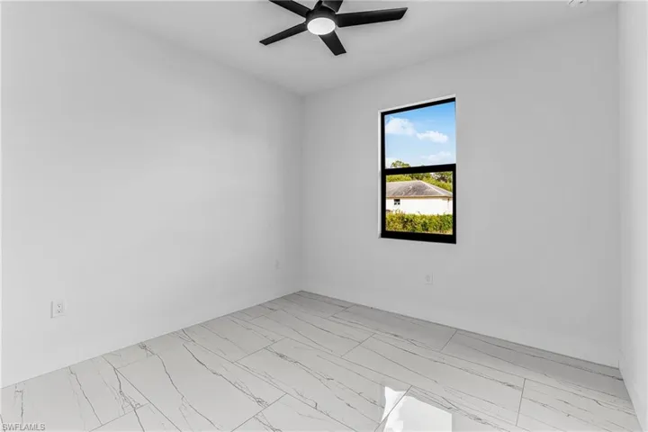 Unfurnished room with light marble finish flooring and a ceiling fan