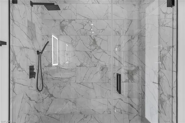 Full bath with a marble finish shower