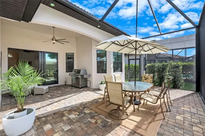 View of patio featuring outdoor dining space, a sunroom, ceiling fan, grilling area, and a lanai