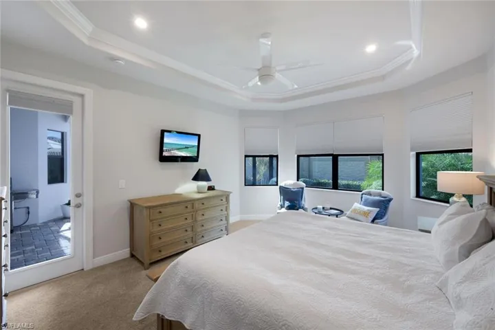 Bedroom featuring ceiling fan, crown molding, a raised ceiling, light colored carpet, and recessed lighting