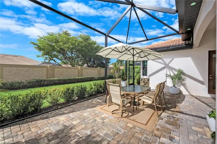 View of patio with a sunroom, outdoor dining area, and a lanai