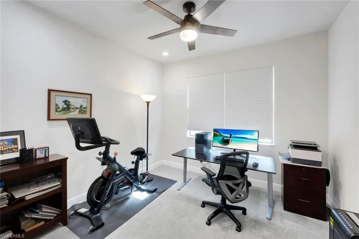 Office with light colored carpet and ceiling fan