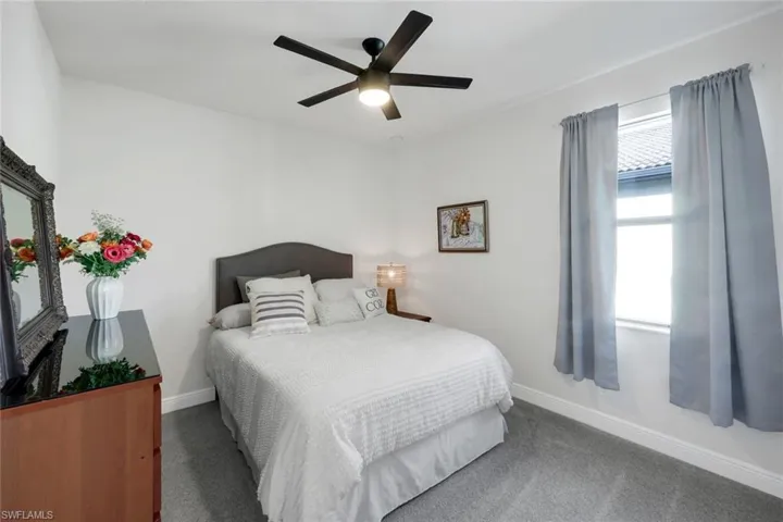 Carpeted bedroom featuring baseboards and a ceiling fan