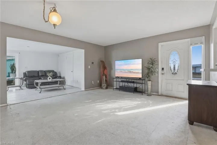 Carpeted living area featuring baseboards