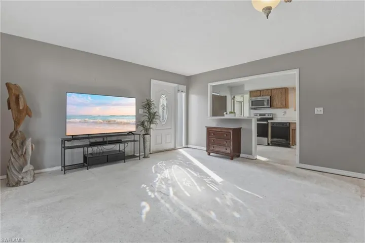 Living room with light colored carpet and baseboards
