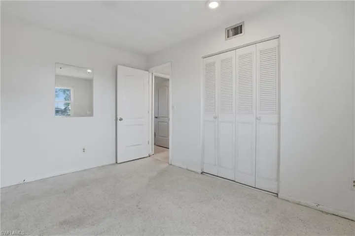 Unfurnished bedroom featuring a closet, speckled floor, and recessed lighting