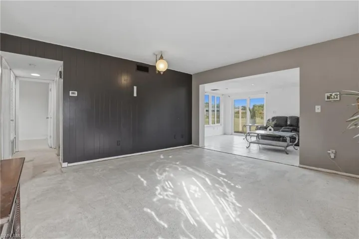 Living room featuring wooden walls and light colored carpet