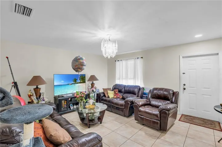 Tiled living room featuring an inviting chandelier