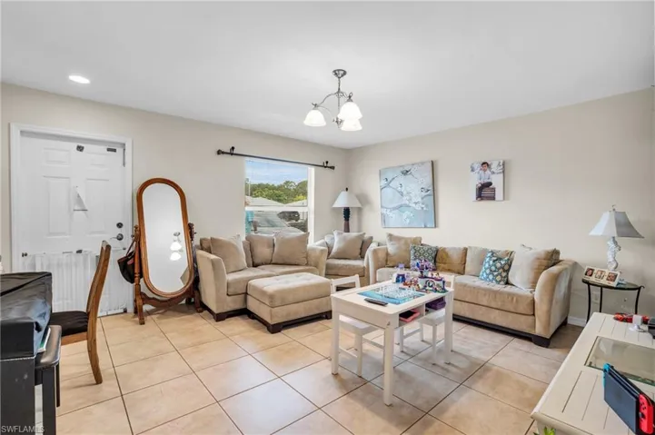 Tiled living room featuring a chandelier