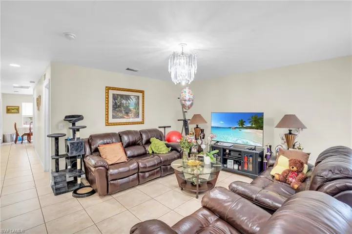 Tiled living room with a notable chandelier