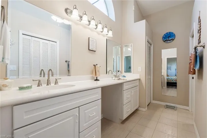 En suite bathroom with dual sinks, shower & walk-in closet