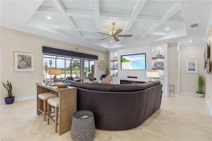 Living room featuring beam ceiling, ceiling fan, light tile patterned floors, and coffered ceiling