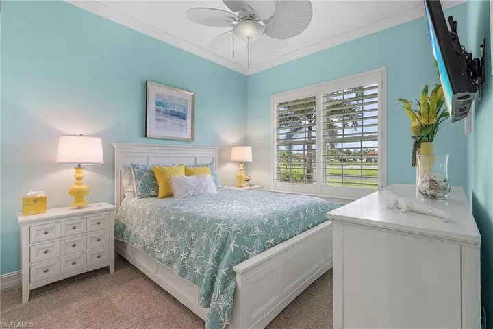 Bedroom featuring ceiling fan, ornamental molding, and light colored carpet