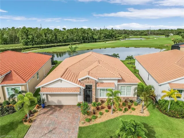 View of front of property featuring a garage, a front lawn, and a water view